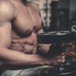 גבר יושב מחזיק משקולות ומבצע אימון כתפיים או אימון יד קדמית