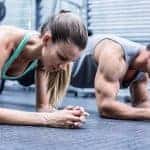 גבר ואישה עם מסת שריר גדולה עובדים על שרירי הבטן