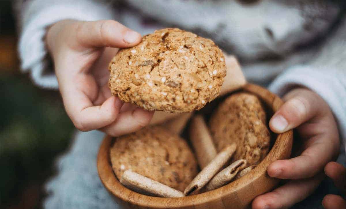 איש מחזיק עוגיית גרנולה גדולה ומגיש אותה למצלמה