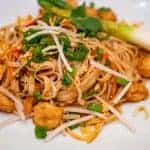 אטריות אורז עם חתיכות טופו מטוגנות, בצל ירוק ובוטנים מלמעלה