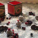 כדורי חלבון התפזורת עם קוקוס מלמעלה ו2 קופסאות אדומות ברקע